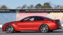 Красный BMW M6 напротив пустых трибун гоночного трека